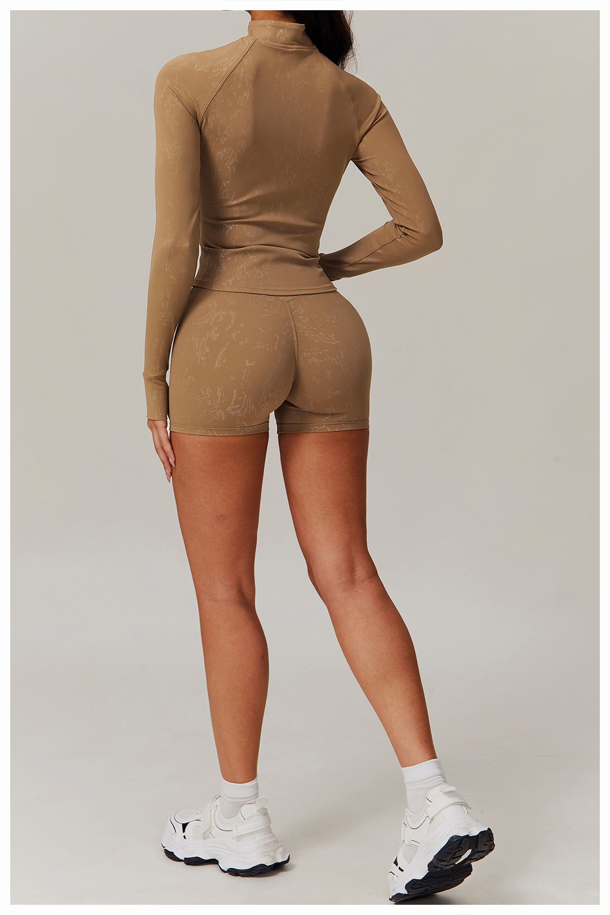 Woman in tan ribbed mock-neck top and high-waisted shorts, stylish langry fashion