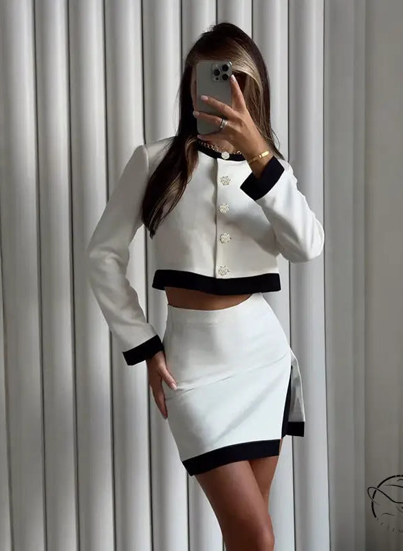 Elegant long sleeve top and short skirt two-piece set in white and black with contrast trim