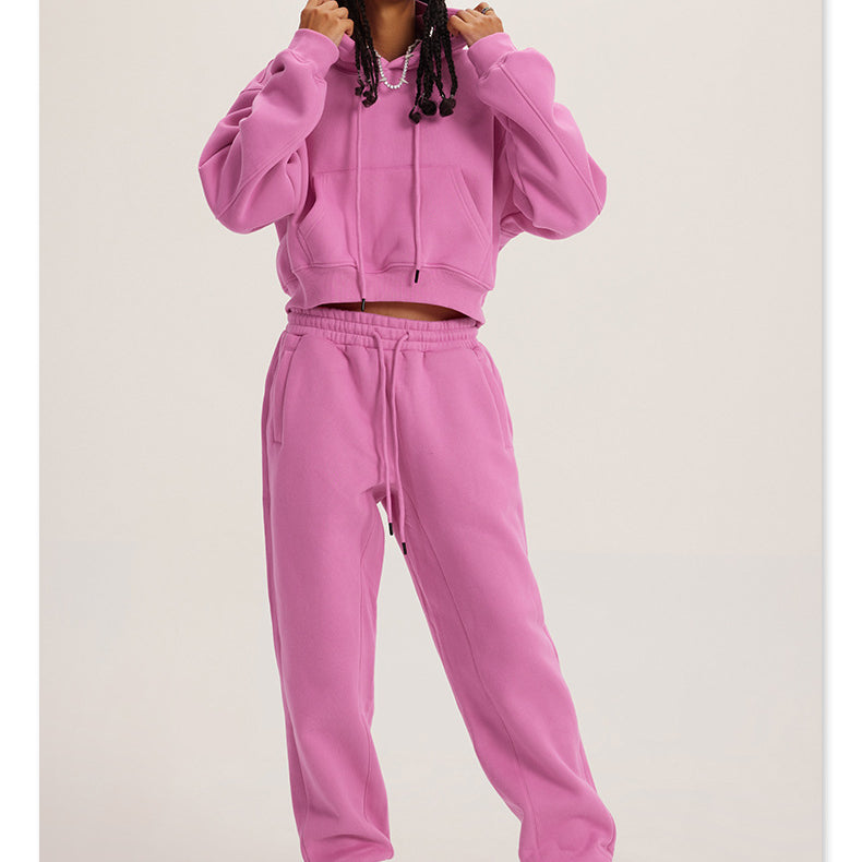Pink sweatsuit with hoodie and joggers, styled with white sneakers for trendy fashion ملابس