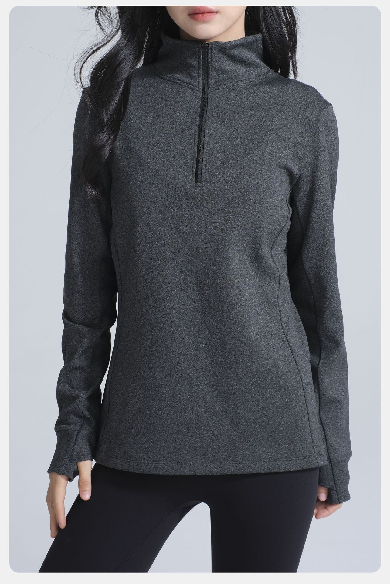 Dark gray long-sleeved athletic top with quarter-zip collar and thumbholes for winter thermal fashion