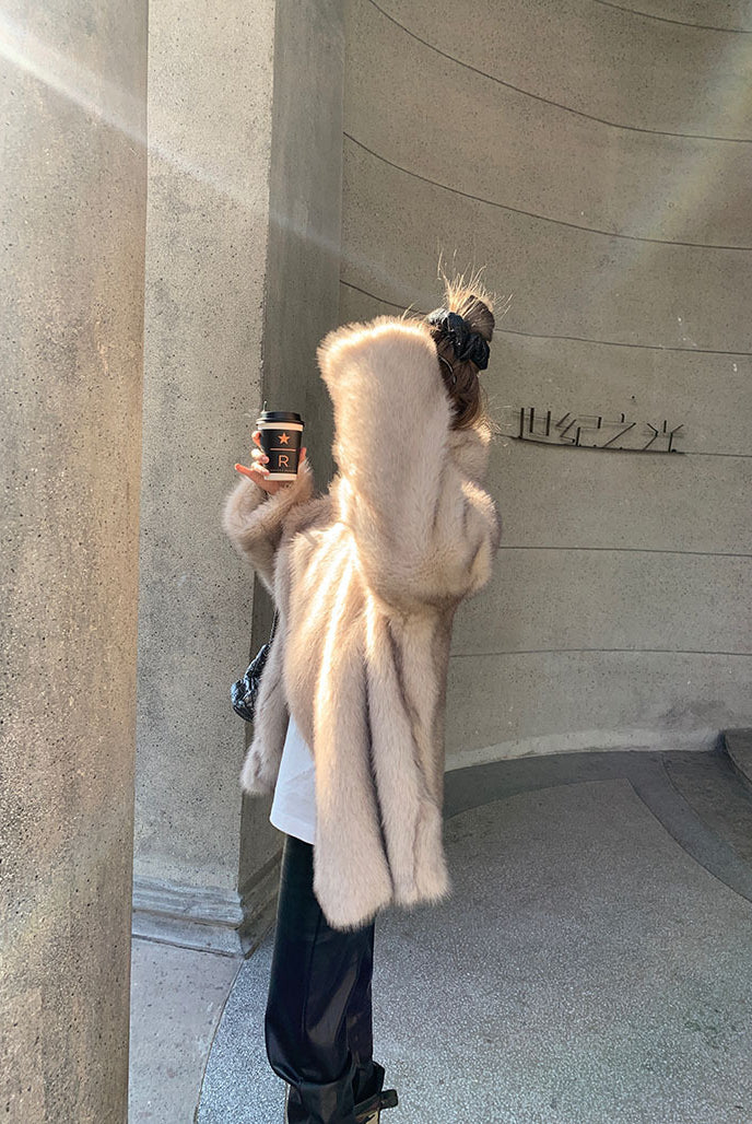 Cream-colored faux fur Langry hooded shearling jacket with black leather boots