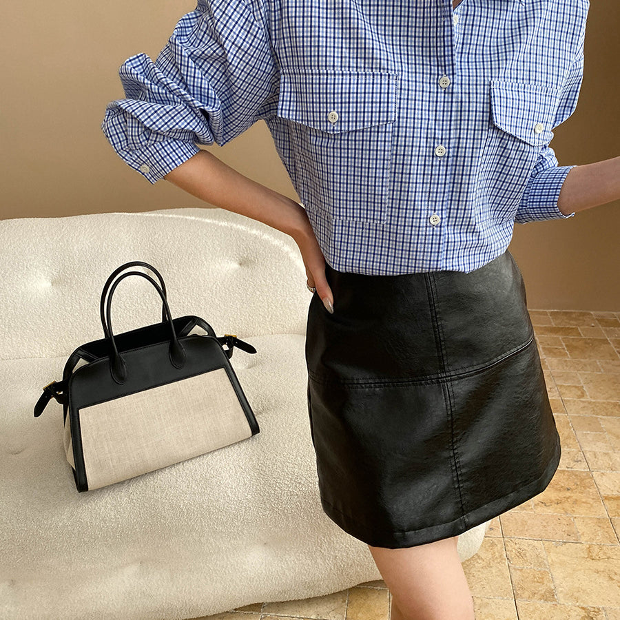 Black and white color-blocked handbag with black handles for a long sleeve fashion look