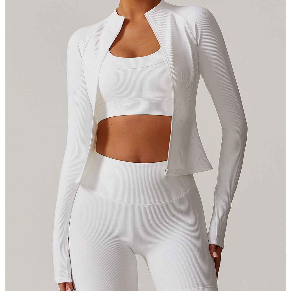 White athletic three-piece langry set includes cropped jacket, sports bra, and shorts