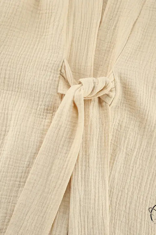 Close-up of beige textured winter pure cotton pajamas fabric with tie closure