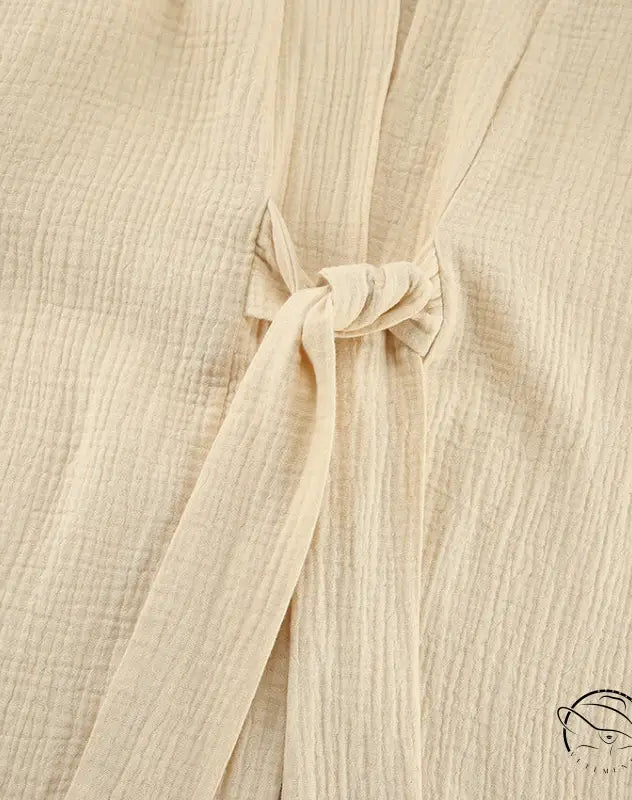 Close-up of beige textured winter pure cotton pajamas fabric with tie closure