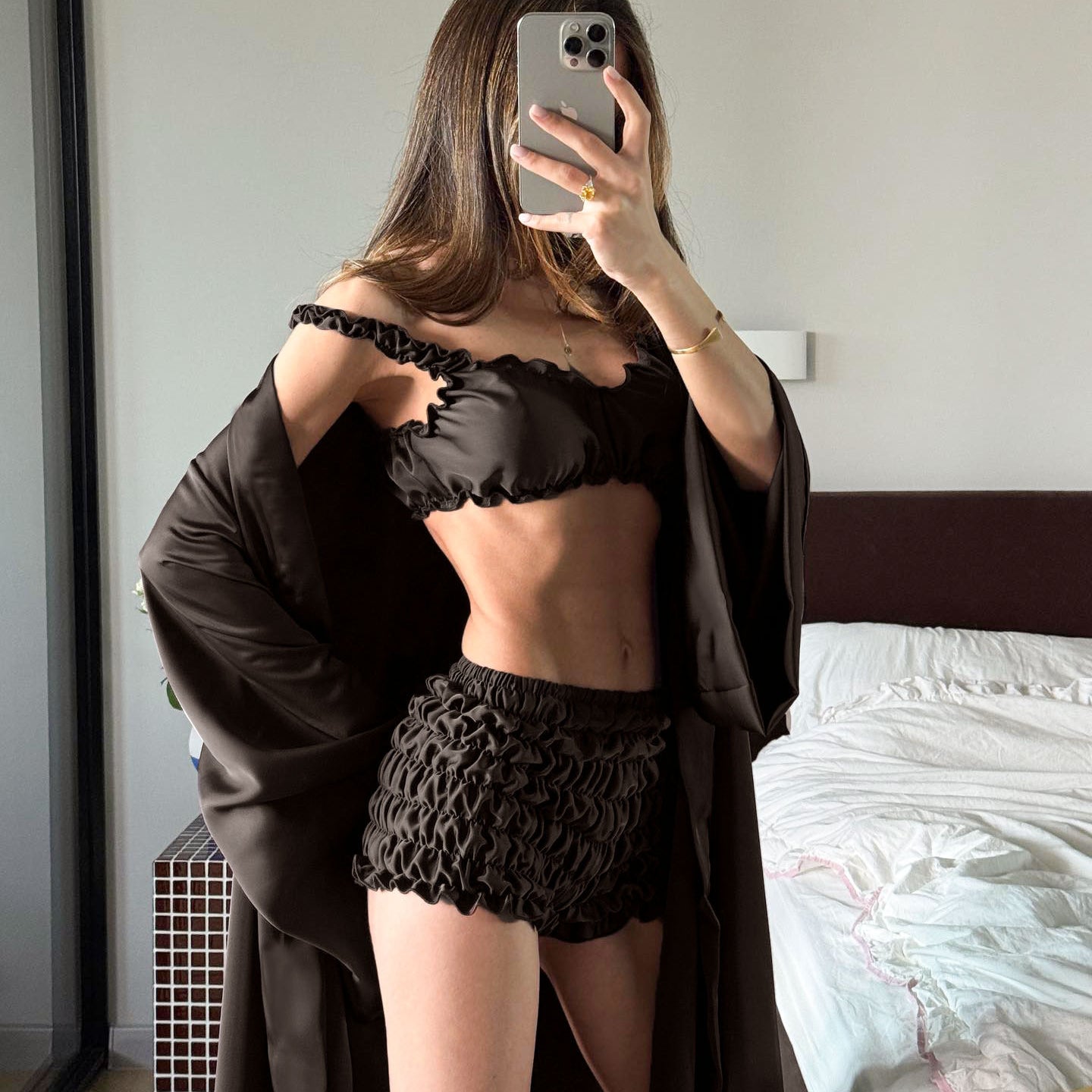 Black lace lingerie set in pleated satin with sheer panel, floral embroidery, and matching robe