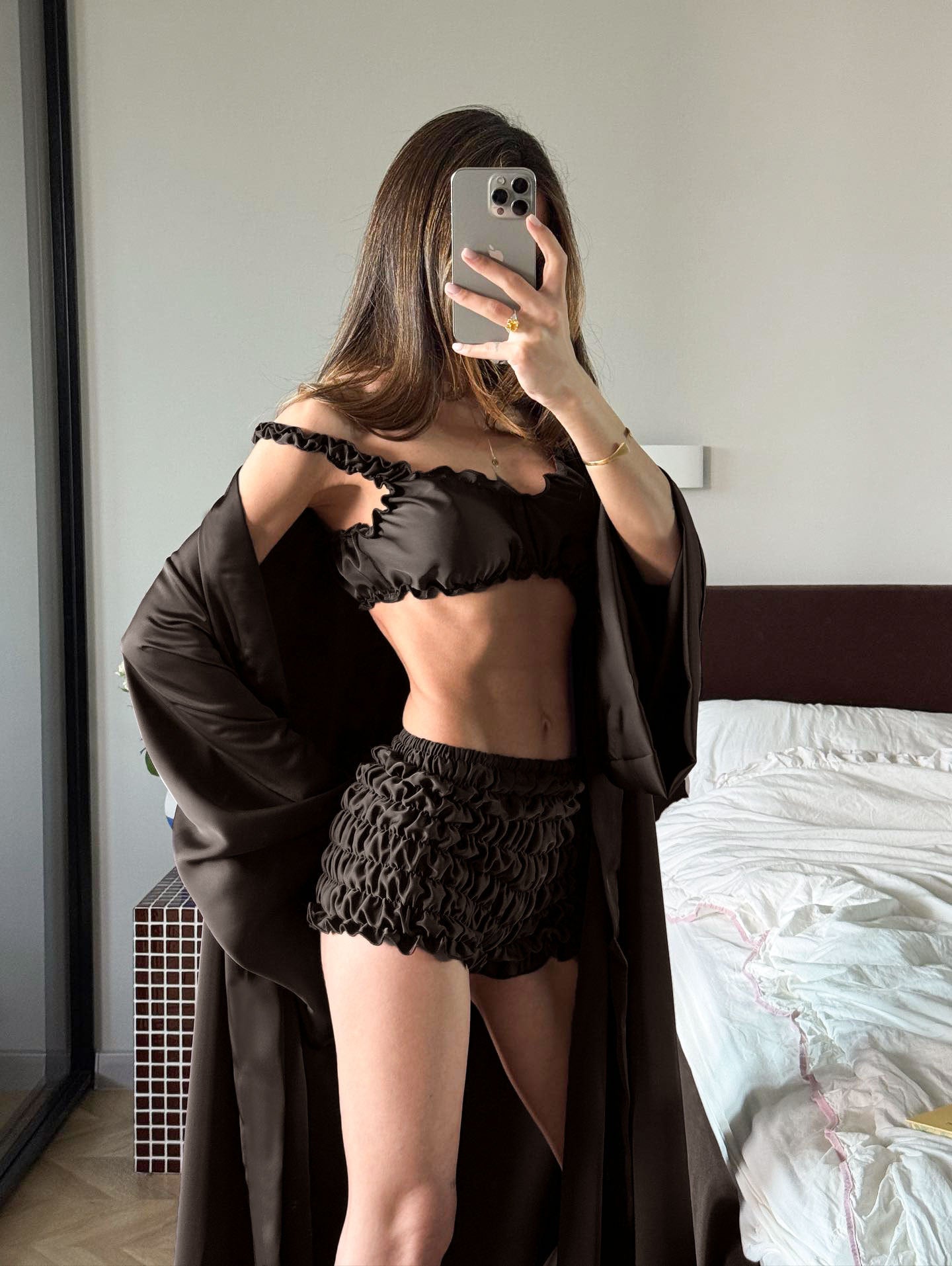 Black lace lingerie set in pleated satin with sheer panel, floral embroidery, and matching robe