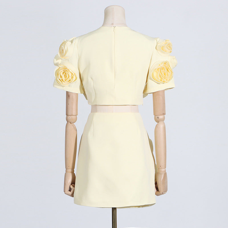 Pale yellow puff sleeve dress with rose adornments displayed on a mannequin