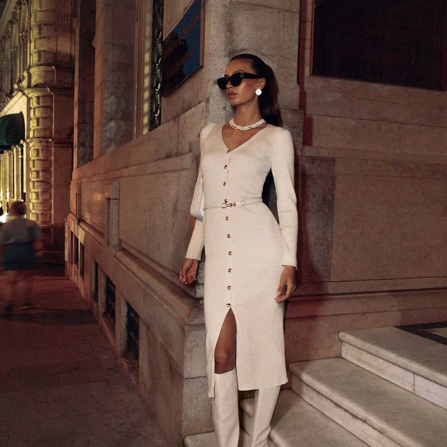 Elegant woman in a white long sleeve knitted dress with boots showcasing Langry fashion