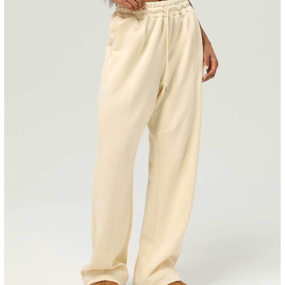 Cream-colored sweatpants with elastic waistband and straight-leg design for casual fitness