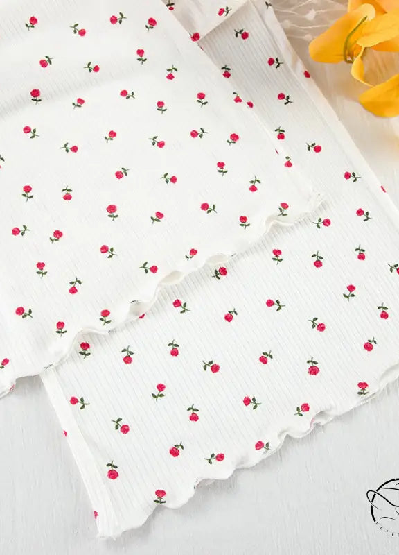 White ribbed knit langry cardigan with red floral pattern and lettuce-edge trim