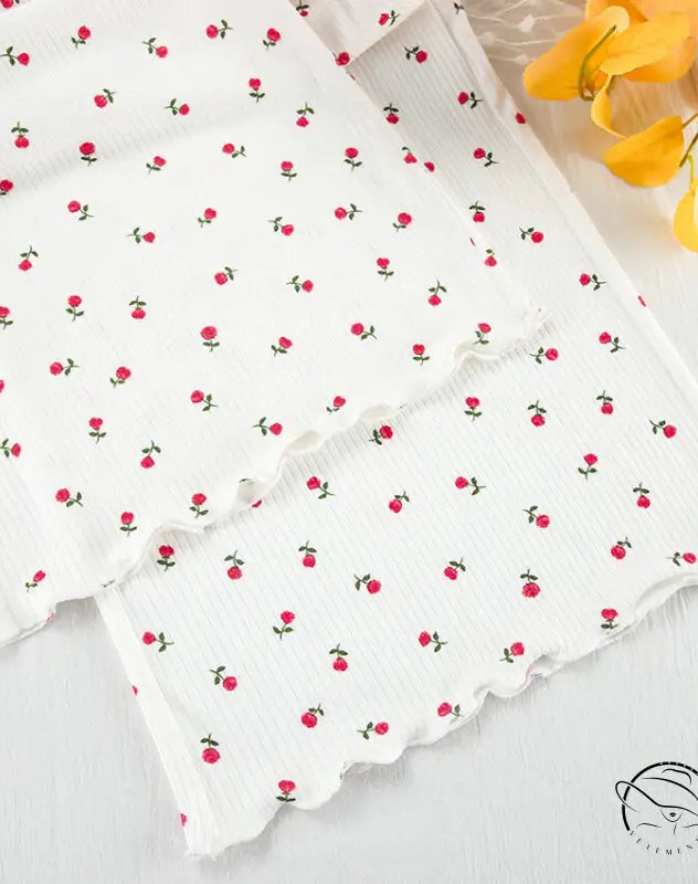 White ribbed knit langry cardigan with red floral pattern and lettuce-edge trim