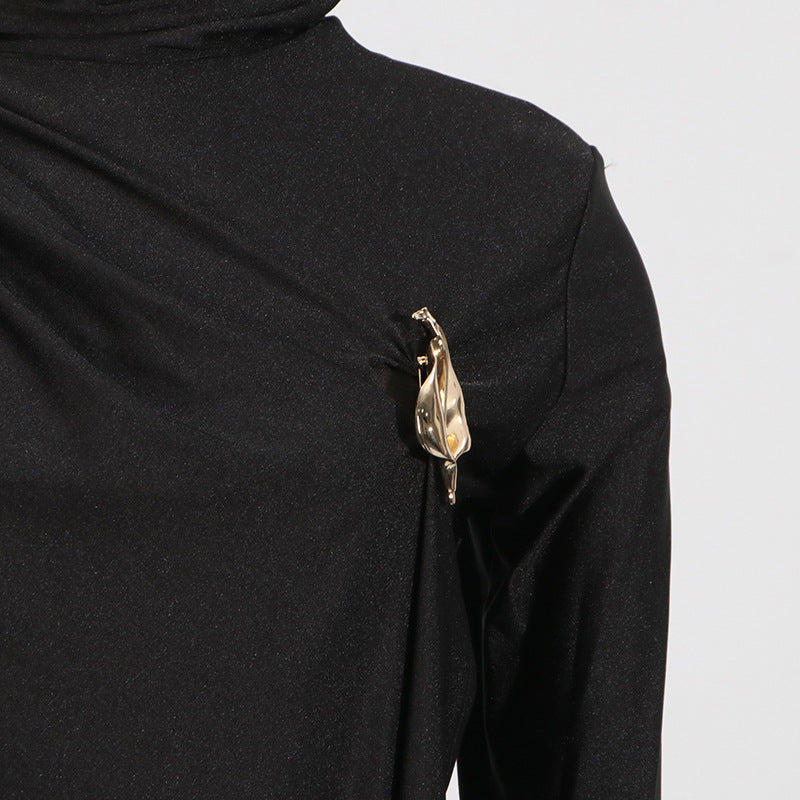 Gold-toned leaf brooch on black fabric of Elegant Socialite Dress for sophisticated fashion