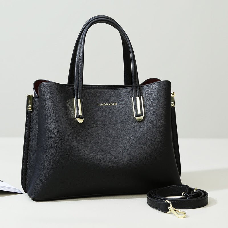Elegant black leather handbag with metallic handles, perfect for fashion and ملابس enthusiasts