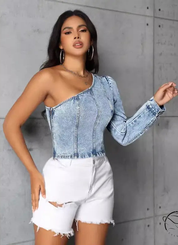 Woman in slim denim one-shoulder top and distressed white shorts