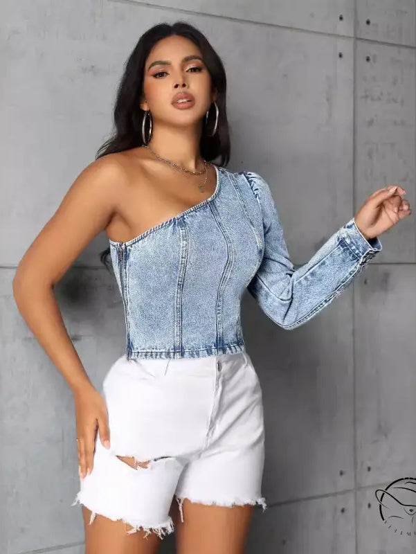 Woman in slim denim one-shoulder top and distressed white shorts