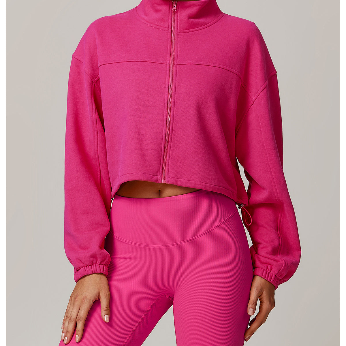Hot pink cropped zip-up athletic jacket with matching leggings for stylish fitness wear