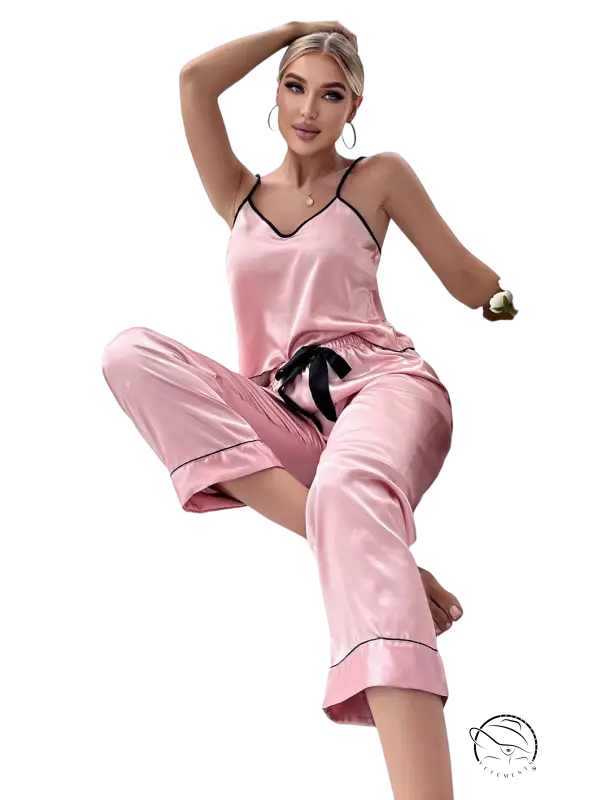 Pink satin pajama set with black trim, tie belt, and black eye mask