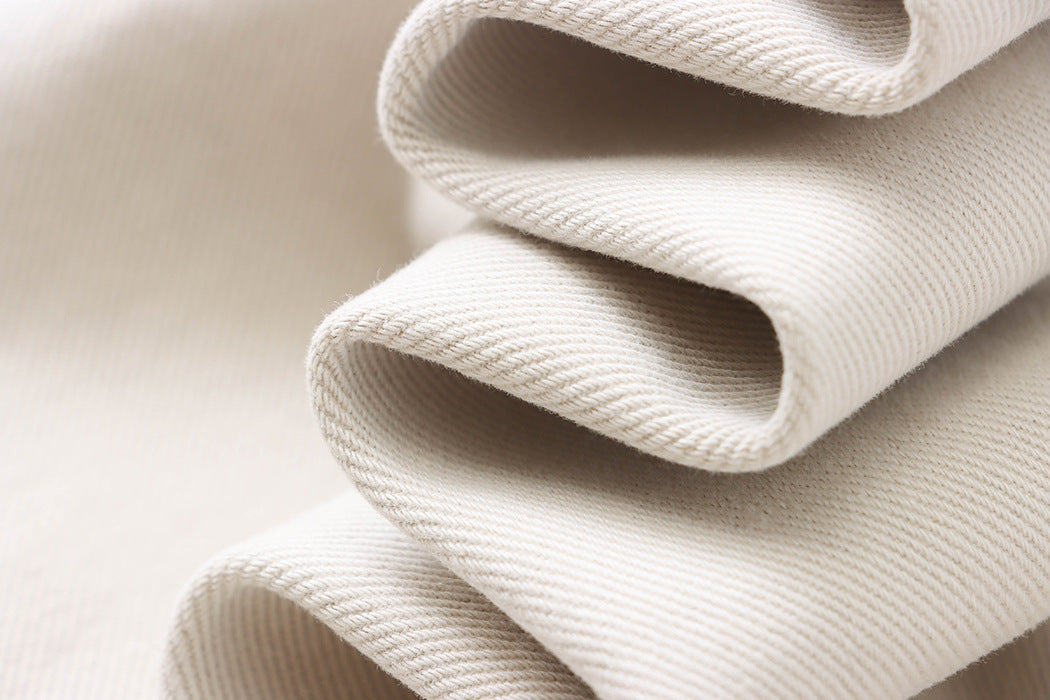 Folded white fabric with ribbed texture showcasing soft waves for Street Design Wide Leg Jeans
