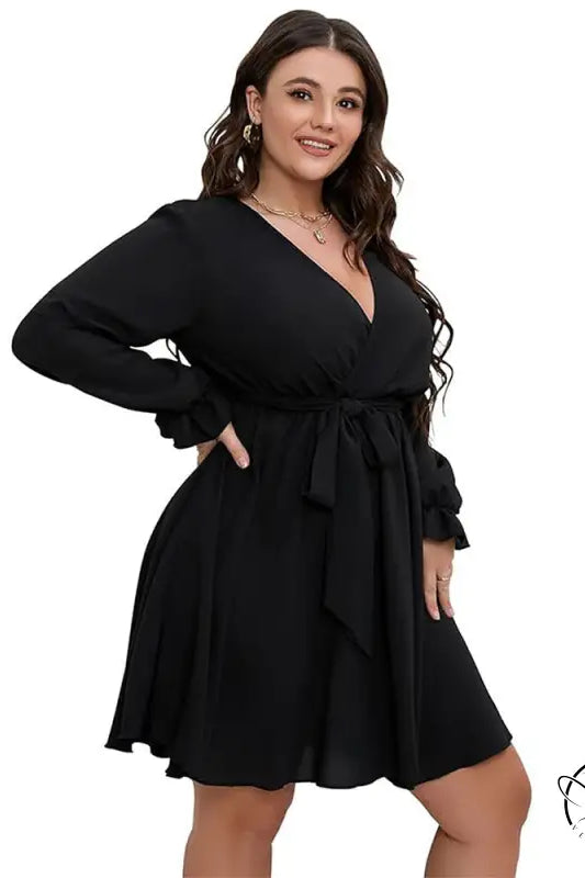 Plus-size woman in black winter office midi dress with V-neck and tie