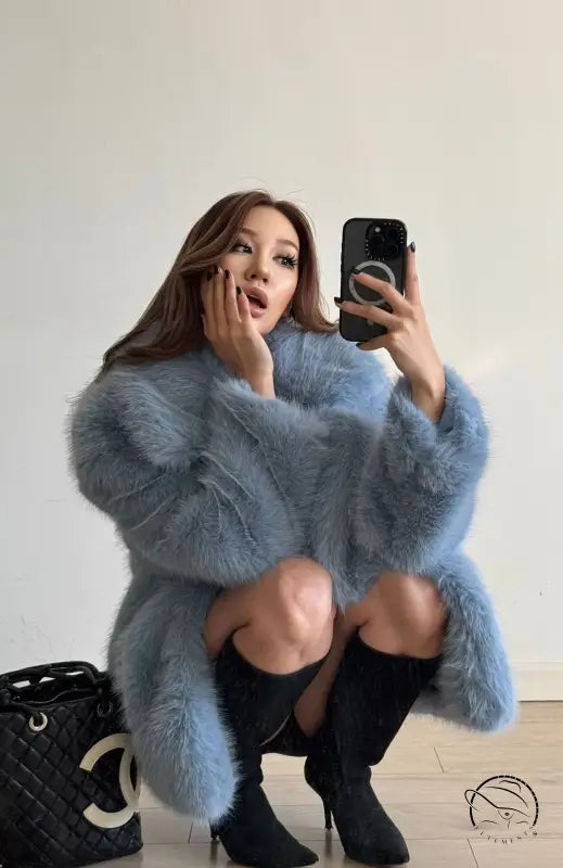 Mid-length Langry faux fur coat with blue fur, black trim, and high-heeled boots