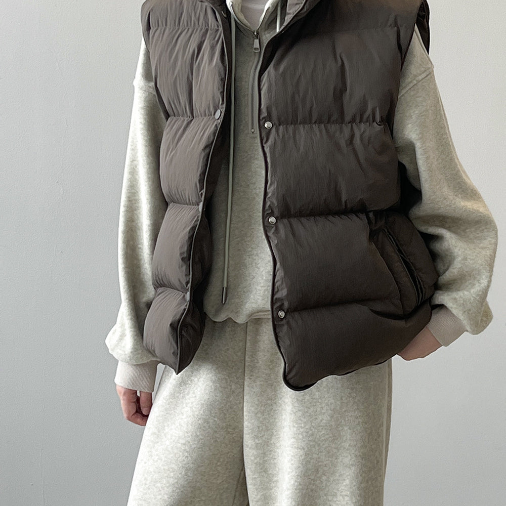 Dark gray puffy down vest over cream sweater and pants, stylish langry fashion ملابس