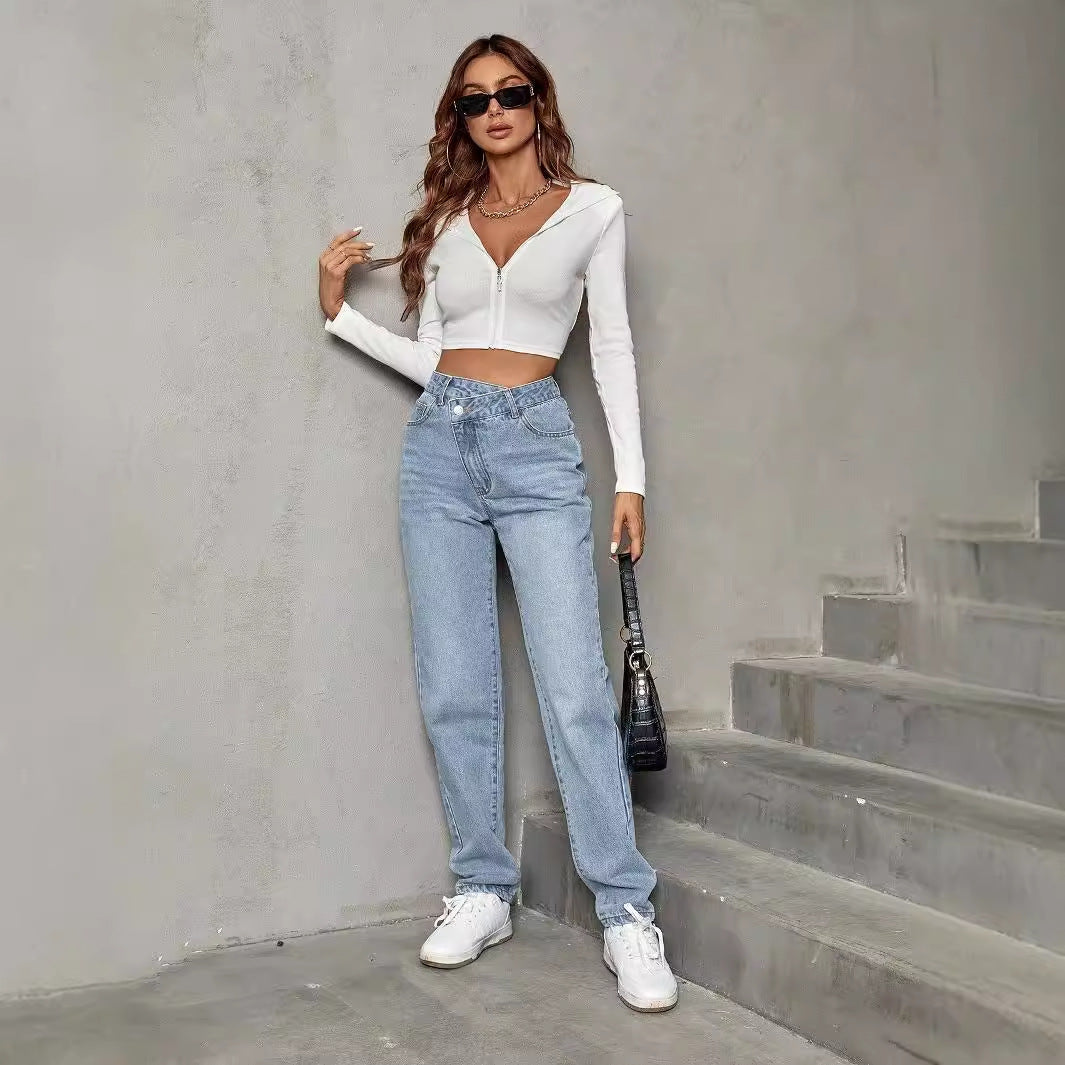 Woman in white crop top and light wash jeans showcasing elastic slimming denim trousers