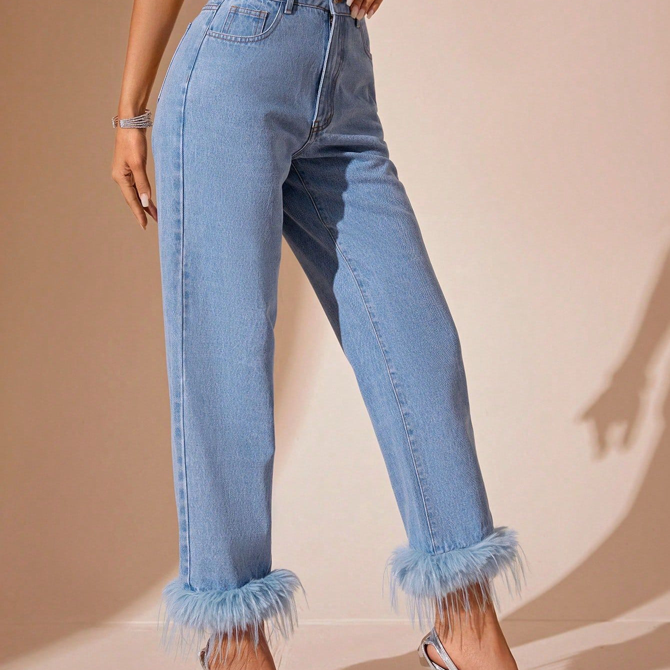 Light-wash blue denim jeans with furry stitching straight faux fur trim at ankles