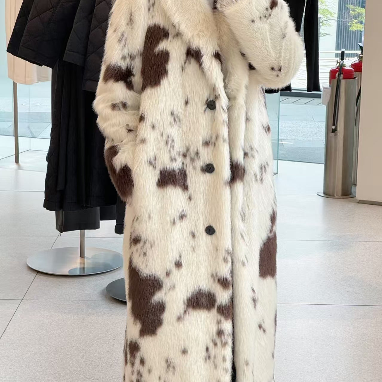 Cozy faux fur long coat with cow print, large buttons, and high collar