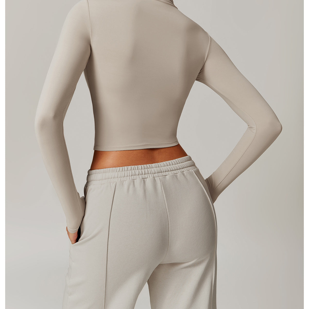 Cropped beige long-sleeved athletic top and matching sweatpants for fitness fashion ملابس