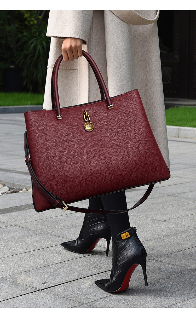 Burgundy leather handbag with gold hardware, a stylish choice for luxury fashion ملابس