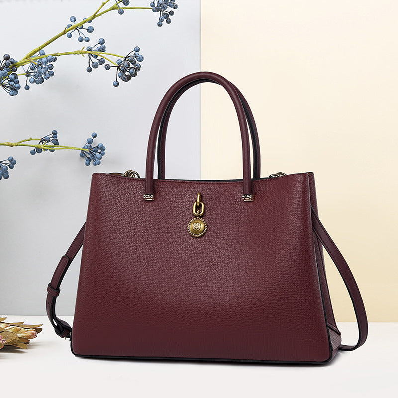 Burgundy leather handbag with gold charm detail, perfect for high-grade luxury fashion