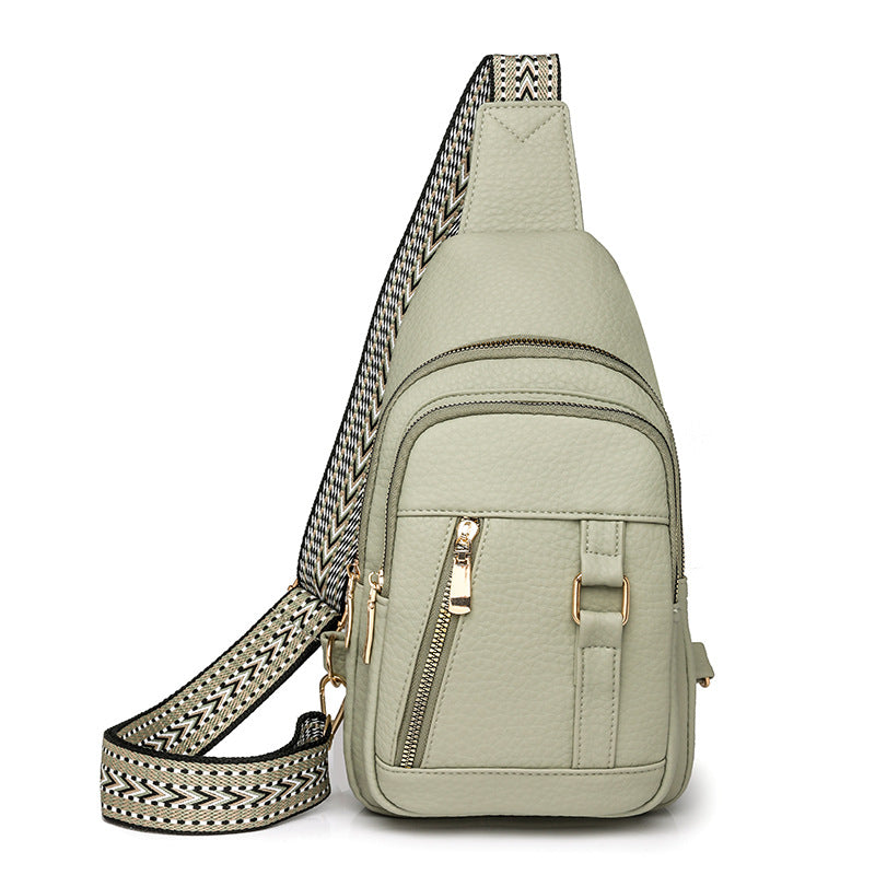 Light green faux leather crossbody bag with patterned strap, perfect for trendy fashion style