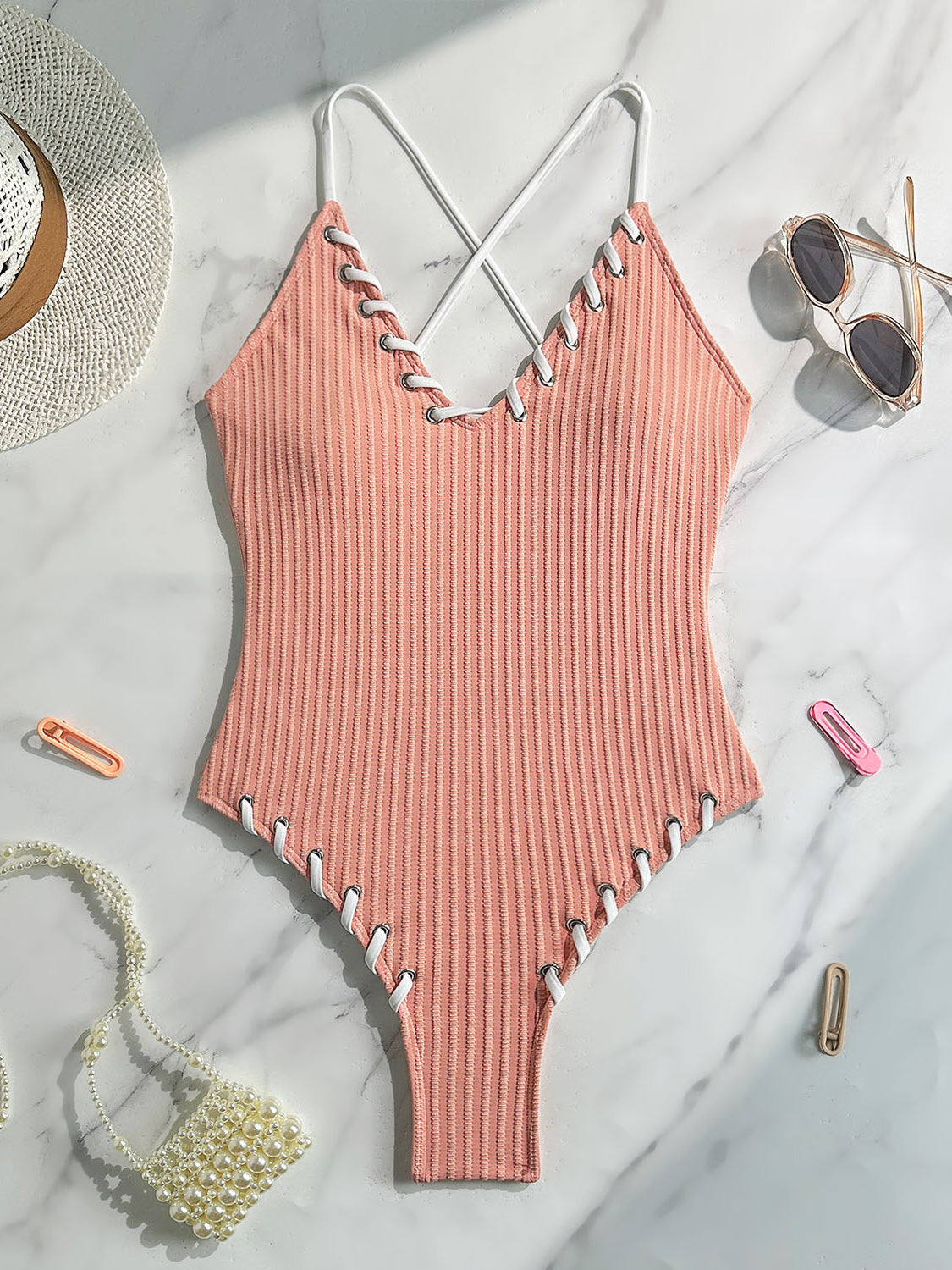 Peach-colored ribbed one-piece swimsuit with criss-cross straps for stylish swimwear fashion