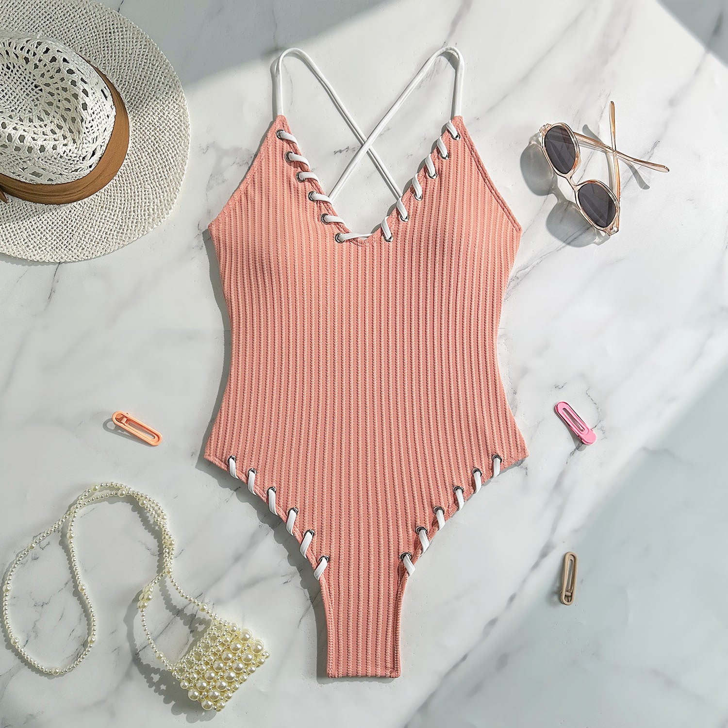 Peach-colored ribbed one-piece swimsuit with criss-cross straps for stylish swimwear fashion