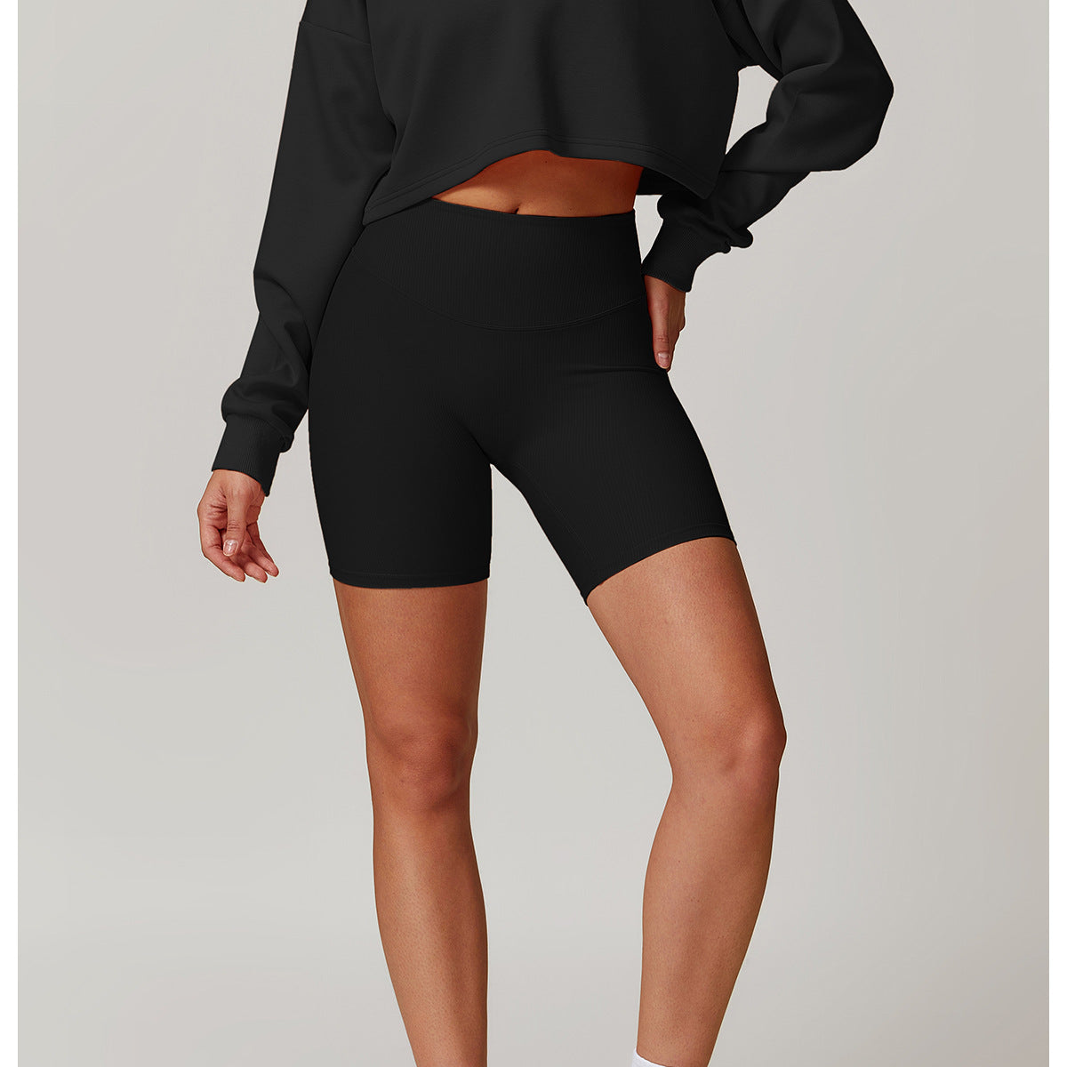 Black cropped sweatshirt and biker shorts athletic set for trendy winter sports fashion ملابس