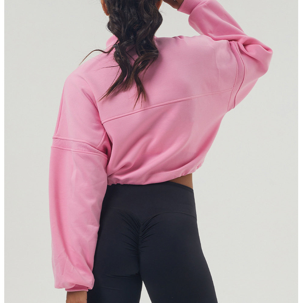 Pink long sleeve cropped sweatshirt paired with black leggings for fashion-forward fitness wear