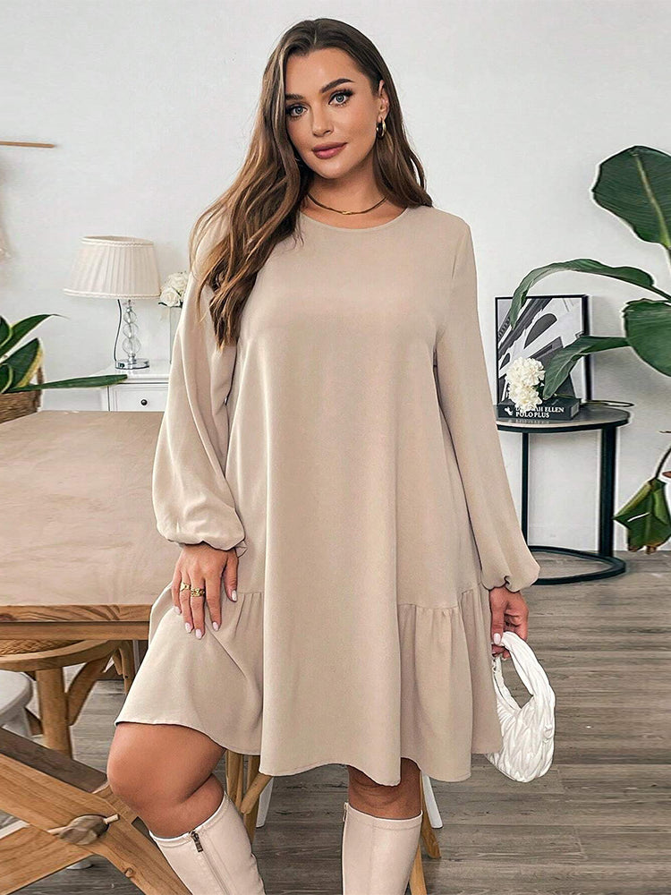 Woman modeling a beige long-sleeved midi dress with ruffled hem and white boots in fashion