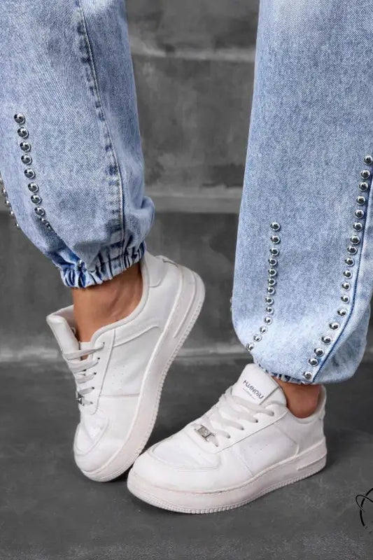 Light-wash match beaded straight jeans with silver studs and white sneakers