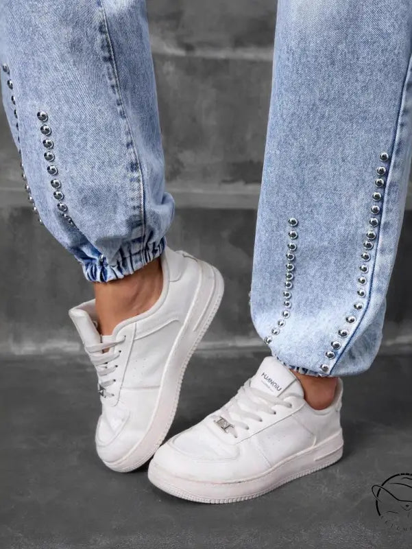 Light-wash match beaded straight jeans with silver studs and white sneakers