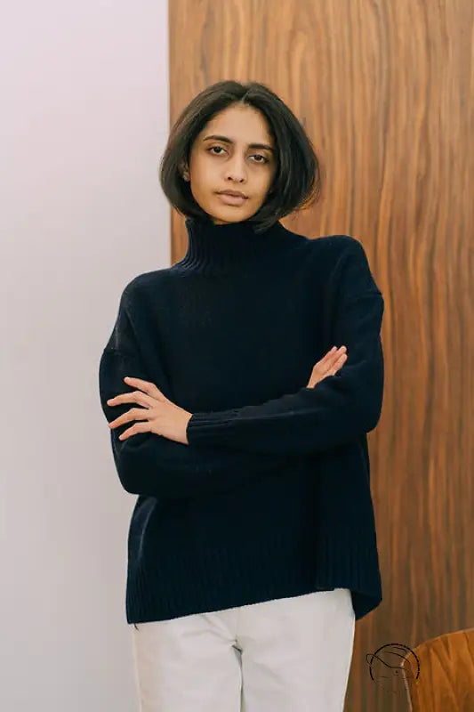 Langry fashion black turtleneck sweater with white pants on wooden door