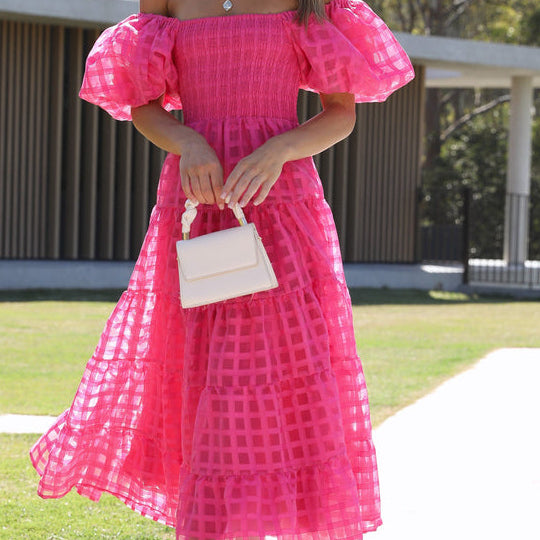 Woman in a pink off-the-shoulder Enchanting Lantern Sleeve Dress, a stunning fashion choice