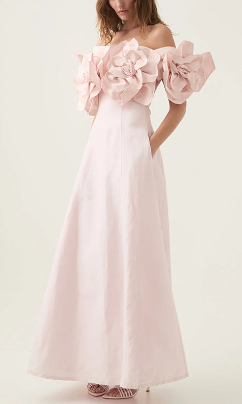 Off-the-shoulder pink maxi dress with floral accents, perfect for fashionable occasions