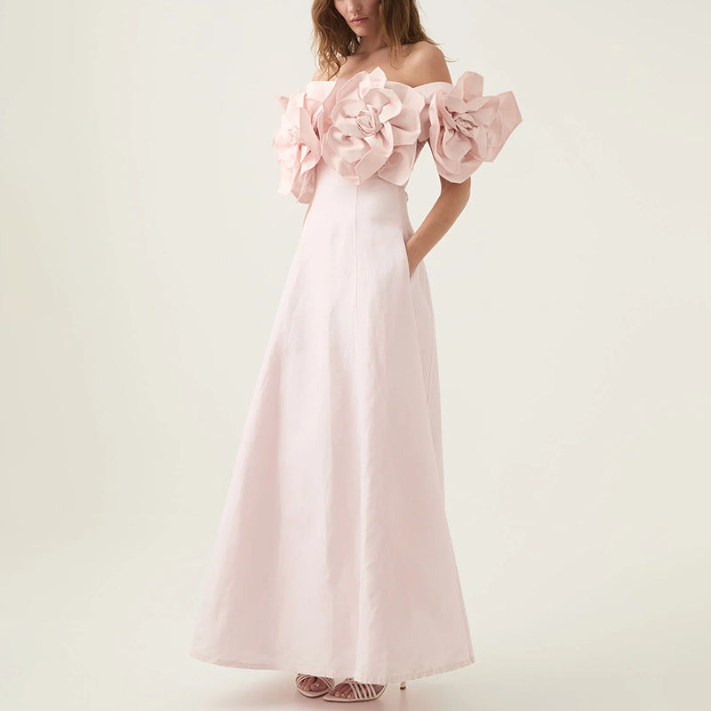 Off-the-shoulder pink maxi dress with floral accents, perfect for fashionable occasions