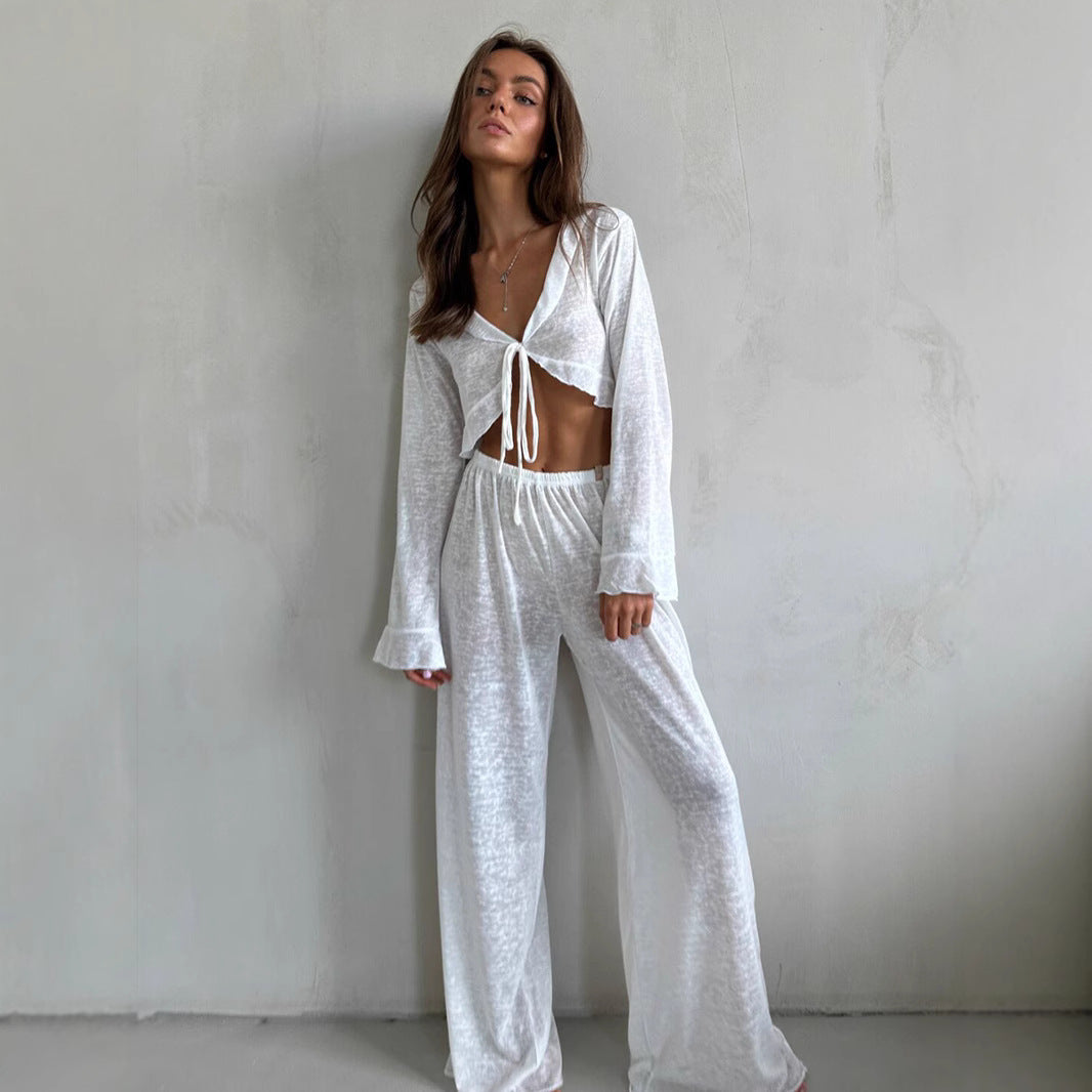 Woman modeling casual loose pajamas with tied crop top and wide-leg pants