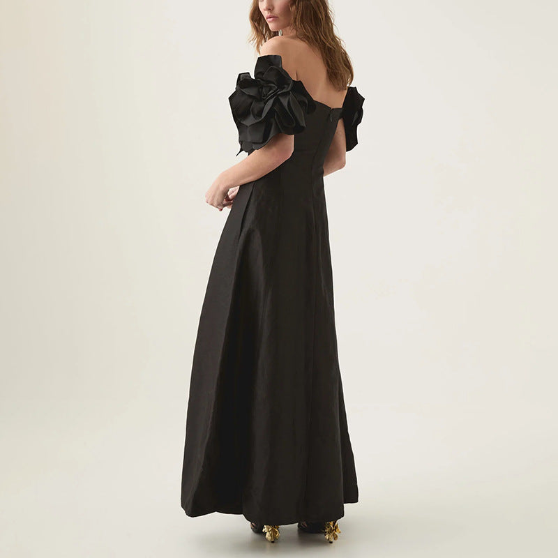 Black off-the-shoulder maxi dress with floral accents, perfect for elegant fashion styling
