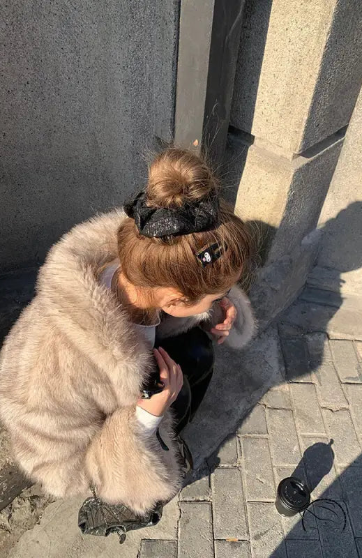 Winter faux fur jacket with black leather accents and pom-pom detail