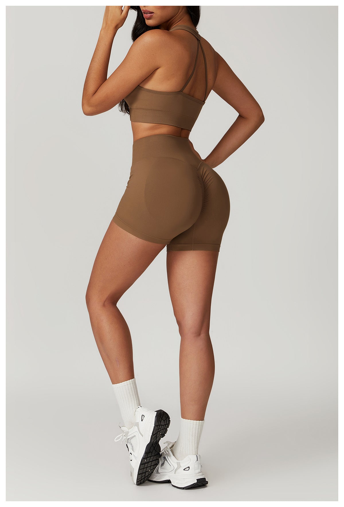 Woman in brown athletic wear showcasing the SEAMLESS YOGA SUIT for bra shorts rhino