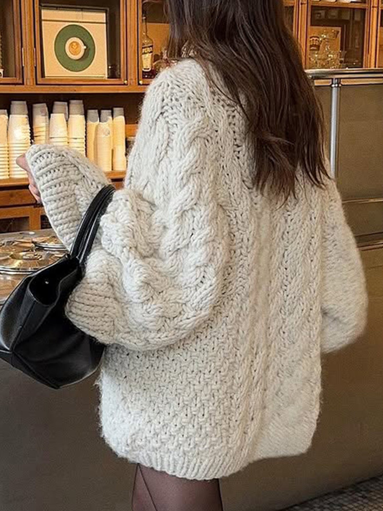 Cream cable knit oversized long sleeve sweater with black leather bag