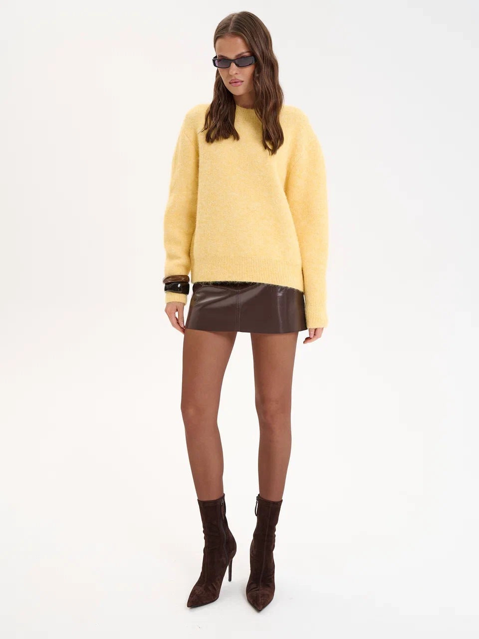 Yellow wool alpaca oversized sweater with black sunglasses and brown leather boots